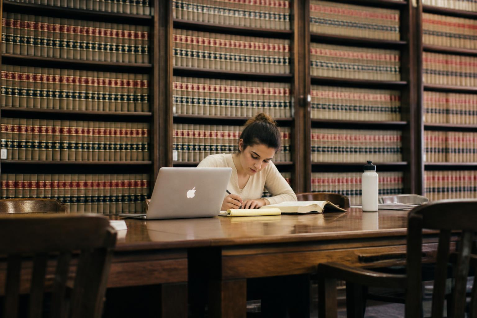 A law student working at a long table in a law library